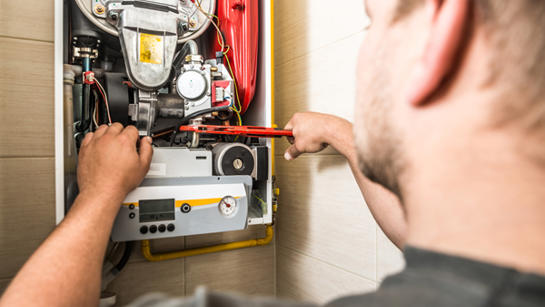 Engineer working on a boiler. Engineer working on a boiler.