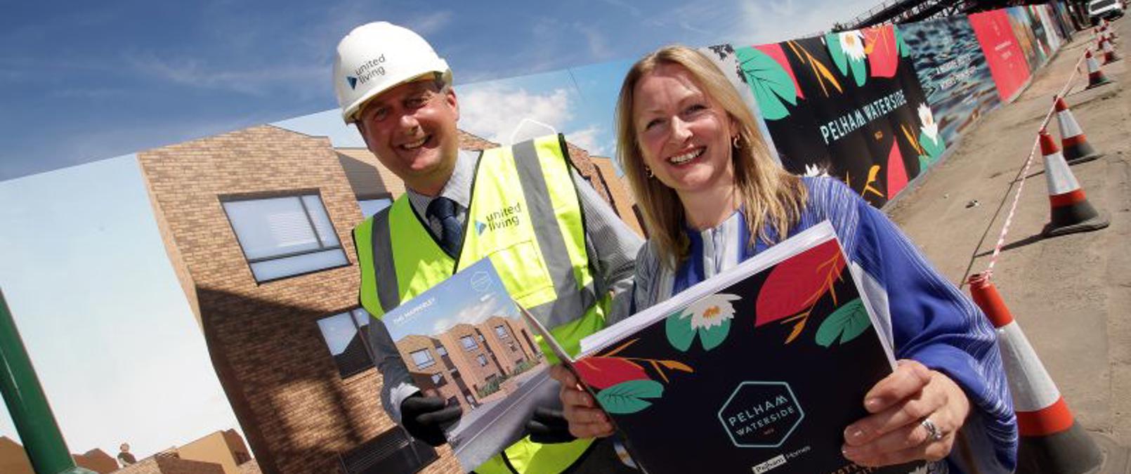 Colleagues Holding Brochures On Development Site