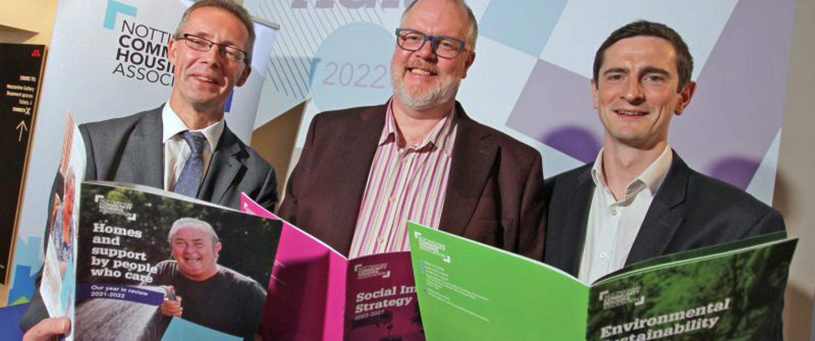 Colleagues Holding Brochures At Annual General Meeting