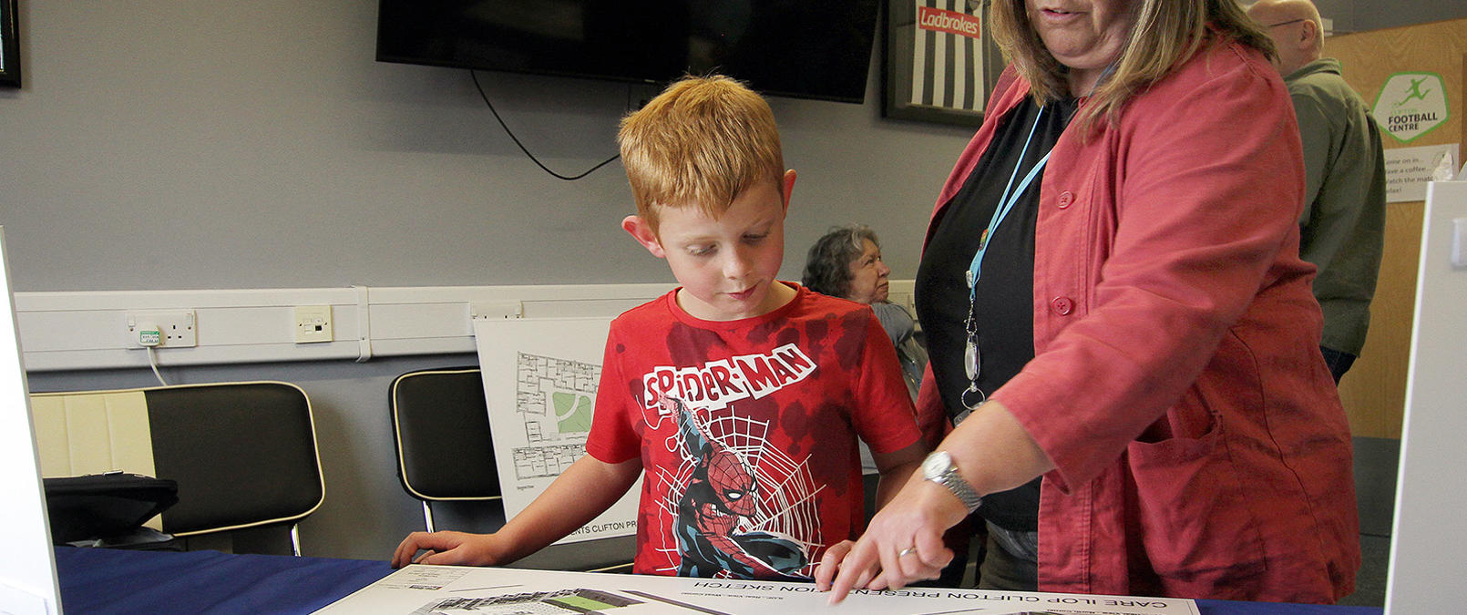 Colleague Showing A Child The Development Plans